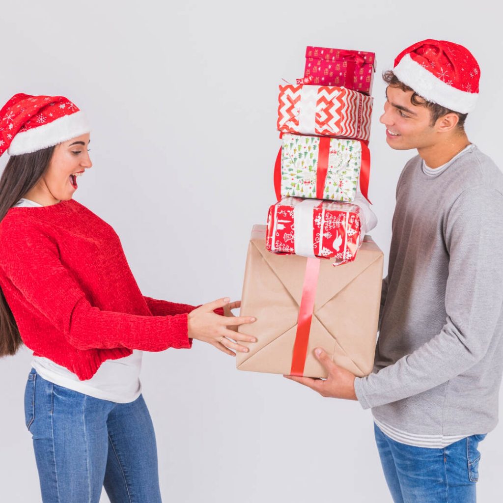 Hombre entregando regalos de navidad a su novia 